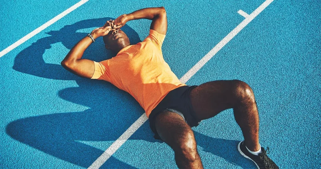 How to Spot Overtraining Symptoms Before They Wreck Your Progress 2 overtraining syndrome - Exhausted runner resting after a race on the field