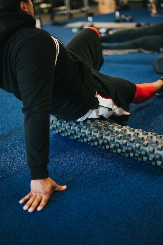 Fitness Recovery Gear: What You Need and Why 2 fitness recovery gear - person in black pants and white shirt using roller foam
